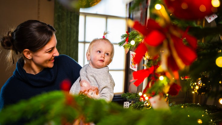 A mother and child admire a Christmas tree in Wimpole Hall, at Wimpole Estate, Cambridgeshire